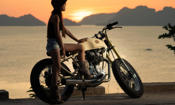 Beautiful girl on a customized Royal Enfield Classic 350 motorcycle